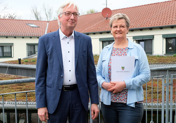 Staatssekretär Wolfgang Beck (l.) überreicht Geschäftsführerin Ines Dehmel den Förderbescheid über 125.687 Euro.